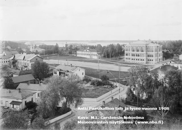 Mustavalkovalokuva Antti Paasikallion talosta lyseon vierellä vuonna 1908.