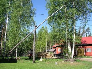 Kaivon vintti on matalakehäisen kaivon vieressä. Takana on museorakennus.