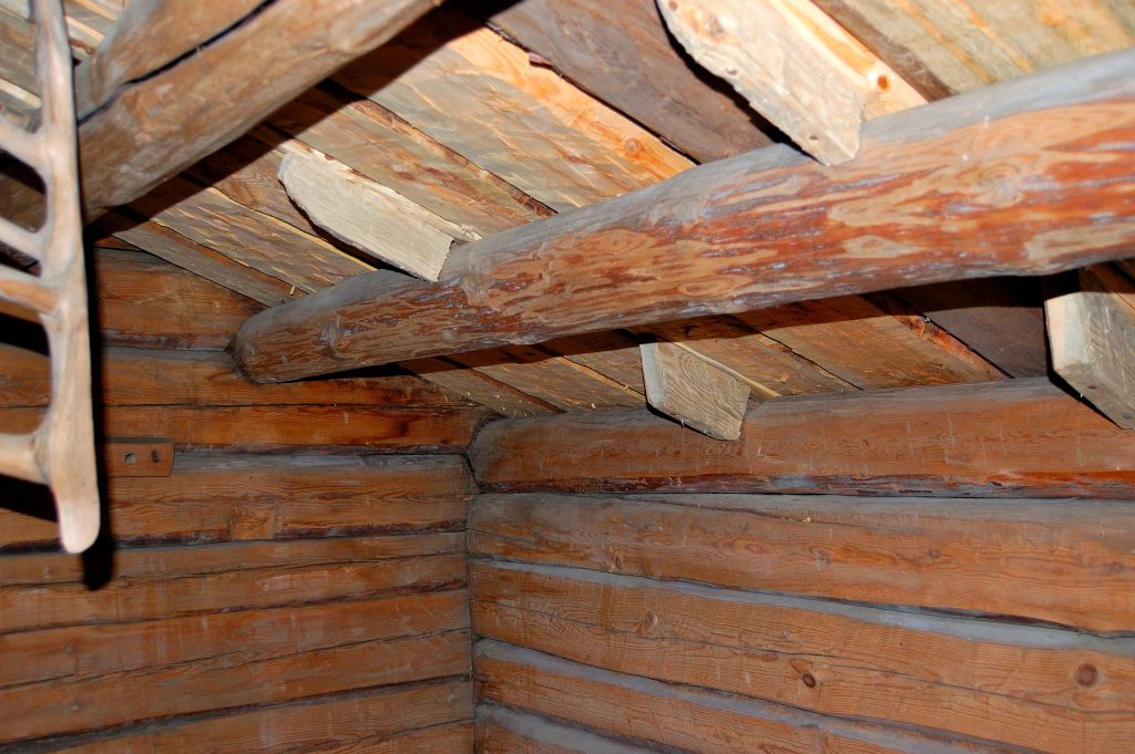 Tuohi-malkakaton rakenne vintillä, missä juuriskoukkuihin naulatut klossit pitävät koukut paikoillaan.