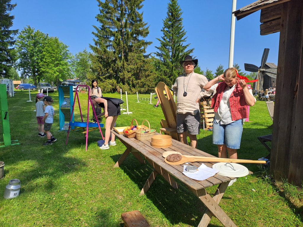 Lapsia ja aikuisia museon pihan nurmikolla aurinkoisena kesäpäivänä.