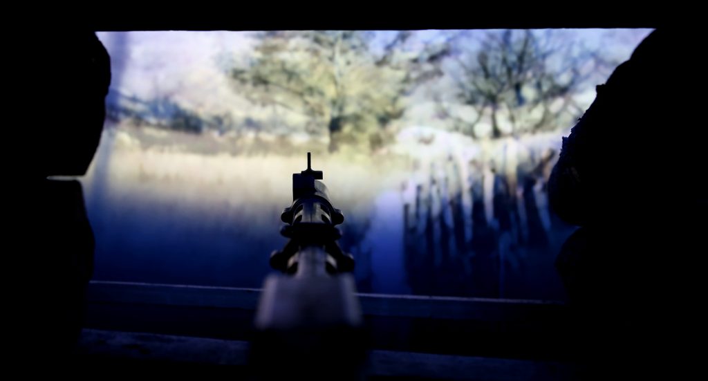 Kivääri osoittaa ulos korsun ampuma-aukosta.