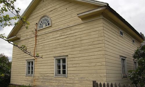 Kuvassa Lyytikkälän tilan päärakennuksen vaakavuorattua ja vaaleaksi maalattua päätyä ruutuikkunoineen. Päätykolmiossa sijaitsevat kissanpenkit ja hämähäkkiverkkoa muistuttava lunetti-ikkuna.