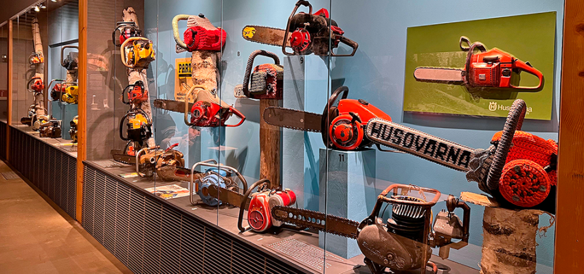 Vitriinissä on esillä oikeita moottorisahoja sekä etualalla langasta kudottu saha.