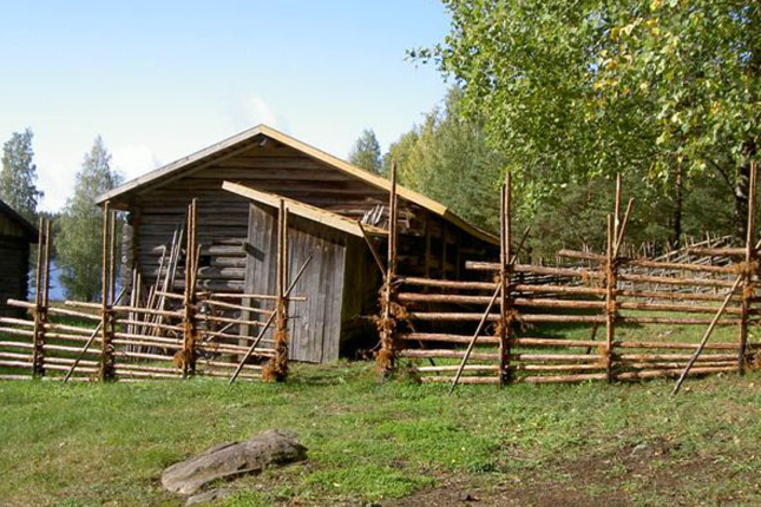 Huussi ja navetan metsänpuoleinen lape hohtavat kirkkaina pärekaton uusimisen jälkeen, ja myös pisteaita on uusittu.