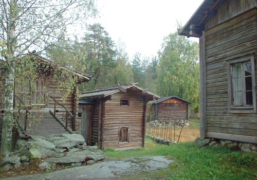 Neljä puista rakennusta. Yksi näistä näyttää asuintalolta, loput enemmänkin ulkorakennuksilta.