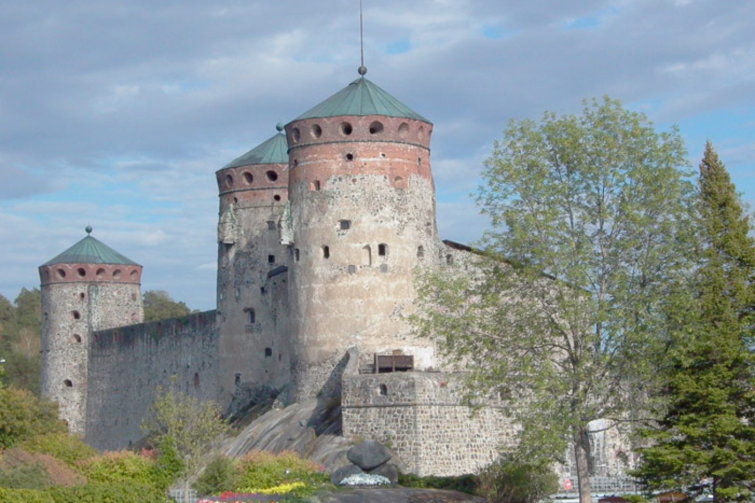 Olavinlinna kuvattuna Tallisaarelta, kolme tornia näkyvissä.